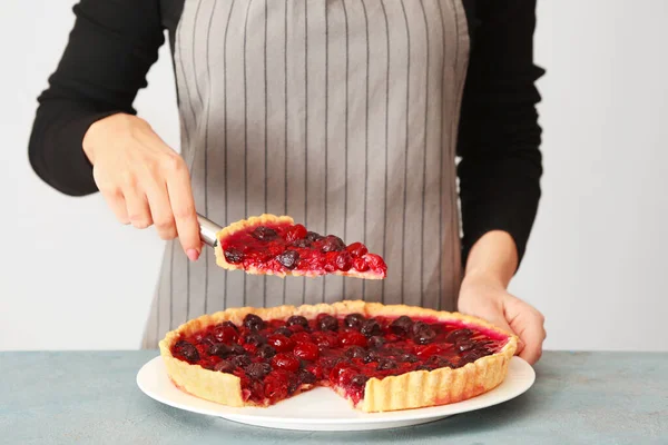 Femme avec une délicieuse tarte aux cerises à table — Photo