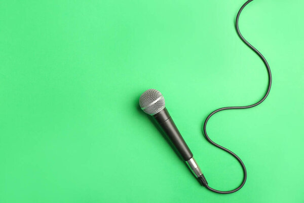 Modern microphone on color background