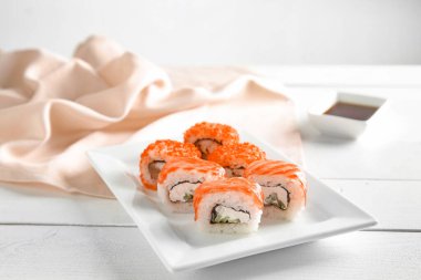 Beyaz ahşap masada lezzetli suşi tabağı.