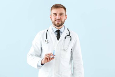 Işık arka planında şırıngası olan doktor.