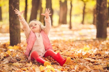sevimli küçük kız sonbahar parkta eğleniyor