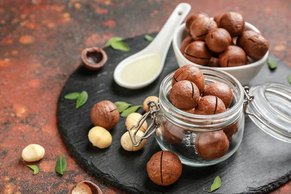 Tasty macadamia nuts on slate plate — Stock Photo, Image