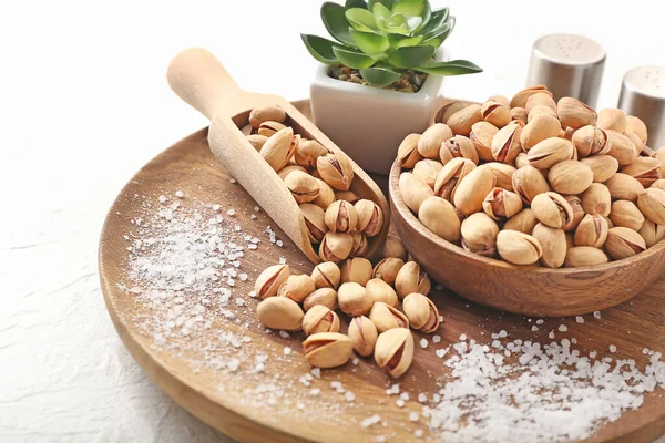 Composition with tasty pistachio nuts on light background — Stock Photo, Image