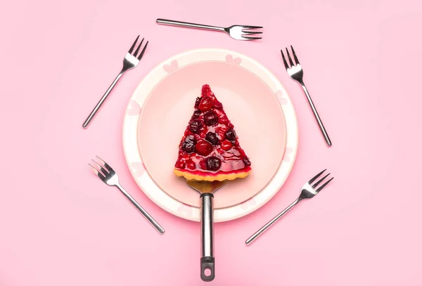 Plate with piece of tasty cherry pie and forks on color background — Stock Photo, Image