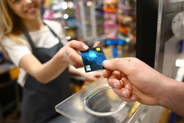 Young man paying for goods in supermarket, closeup — ストック写真