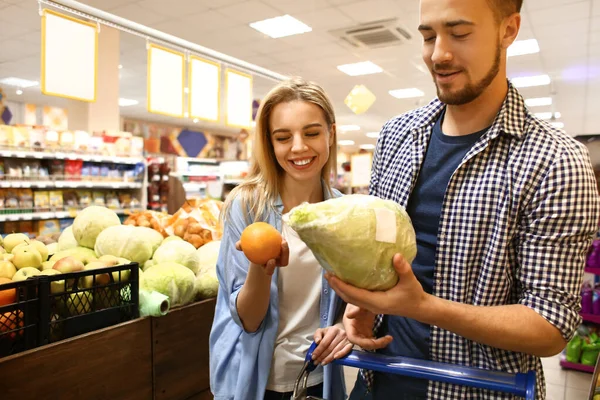 Молода пара вибирає їжу в супермаркеті — стокове фото