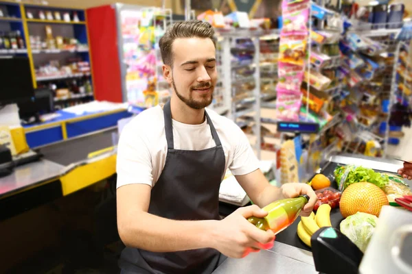 Muž pokladní odbavování zboží v supermarketu — Stock fotografie