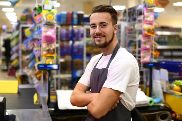 Portrait of male cashier in supermarket