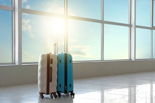 Suitcases in hall of airport on sunny day — Stock Photo, Image