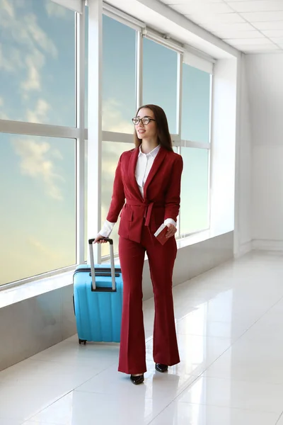 Молодая предпринимательница с чемоданом в зале аэропорта — стоковое фото