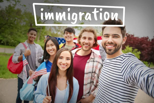 Group of immigrants with USA flags taking selfie outdoors — 图库照片