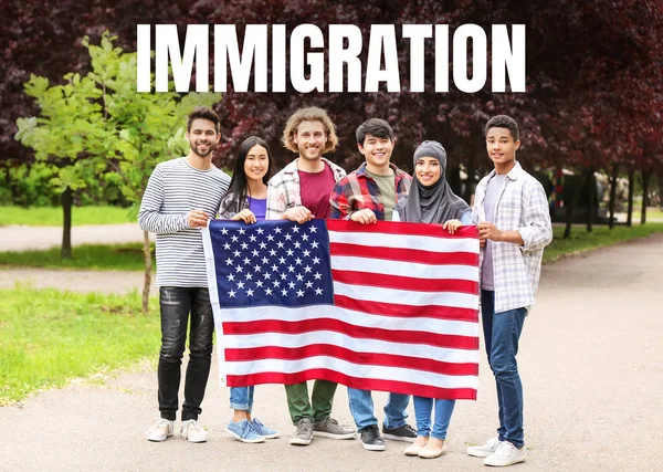 Fiatal bevándorlók csoportja amerikai zászlóval a parkban — Stock Fotó