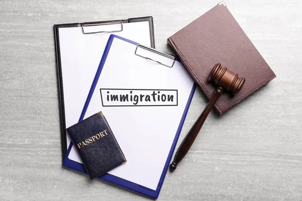 Judge's gavel, clipboards, book, passport and clipboard with text IMMIGRATION on table — Stock Photo, Image