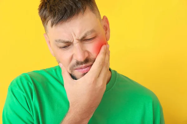 Férfi szenved fogfájás a színes háttér — Stock Fotó