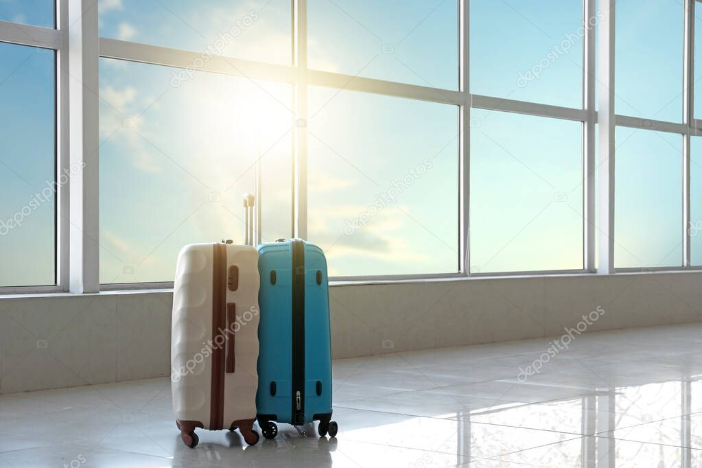 Suitcases in hall of airport on sunny day