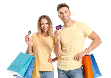 Beyaz arka planda kredi kartları ve alışveriş torbaları olan genç bir çift.