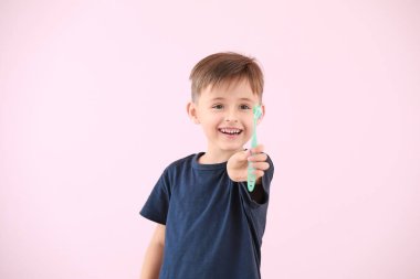 Arka planda diş fırçalayan küçük bir çocuğun portresi