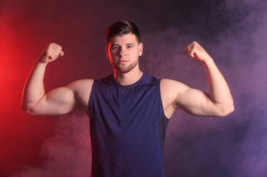 Sportif genç adam koyu arka plan üzerinde