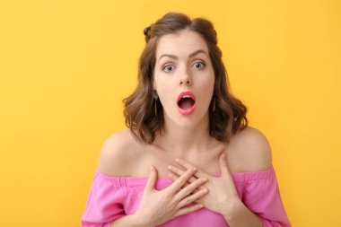 Renkli arka planda şaşırmış genç bir kadın.