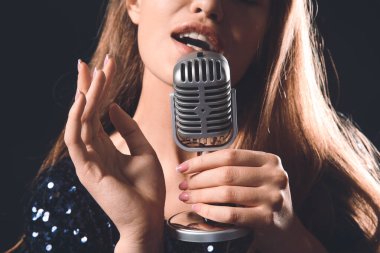 Sahnede mikrofonlu güzel bayan şarkıcı, yakın plan.