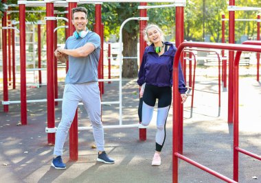 Sportif genç çift dışarıda spor alanında antrenman yapıyor.