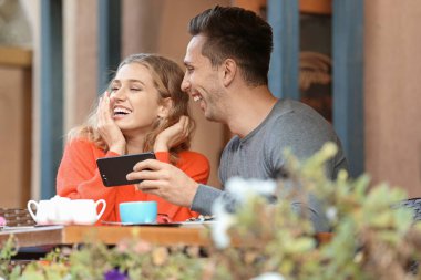 Kafede romantik bir randevuda olan mutlu genç çift