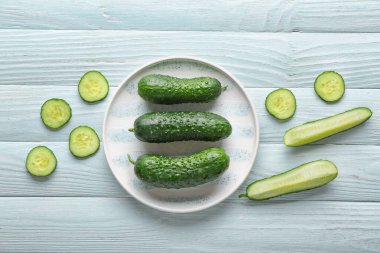 Beyaz ahşap arka planda taze salatalıklı tabak.