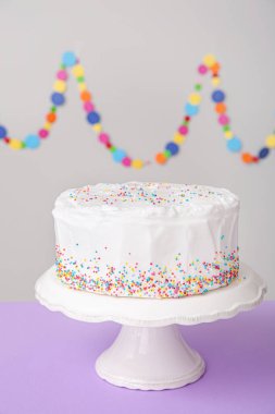 Gri arkaplanlı masada lezzetli bir doğum günü pastası.