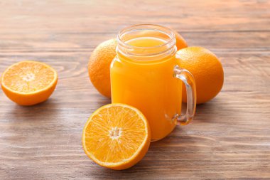 Mason kavanozu taze portakal suyu ahşap masada.