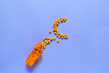 Kavanoz ve dağınık vitaminler renkli arkaplanda C harfi şeklinde.
