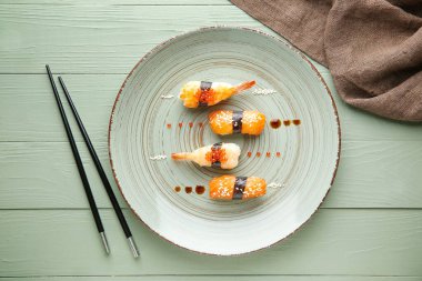 Ahşap masa üzerinde lezzetli suşi ile plaka