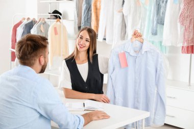 Müşteri modern kuru temizlemeciden kıyafet alıyor.