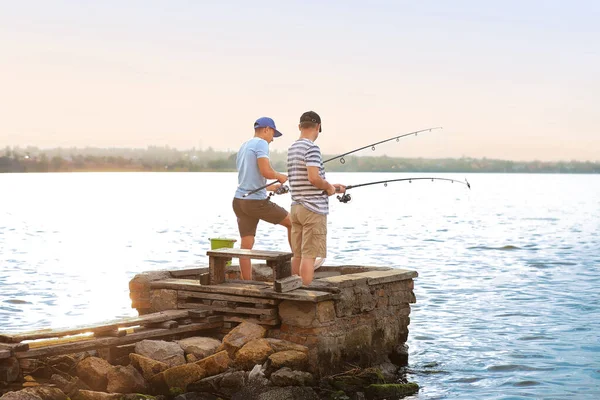 Młody człowiek i jego ojciec łowią ryby na rzece — Zdjęcie stockowe