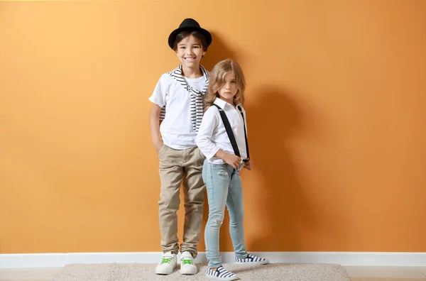 Стильные маленькие дети возле цветной стены — стоковое фото
