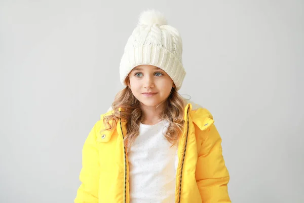 Stylish little girl in winter clothes on light background — Stock Photo, Image