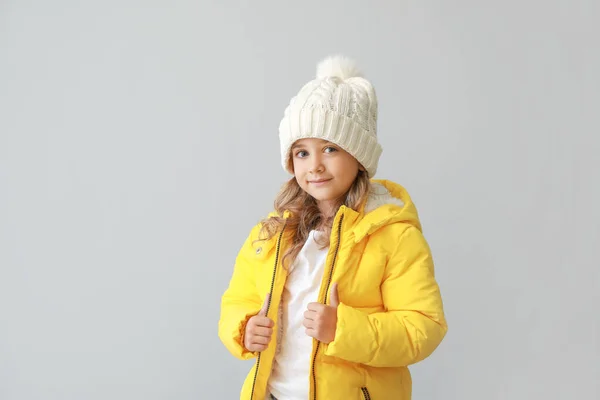 Stylish little girl in winter clothes on light background — Stock Photo, Image