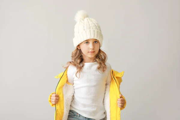 Stylish little girl in winter clothes on light background — Stock Photo, Image