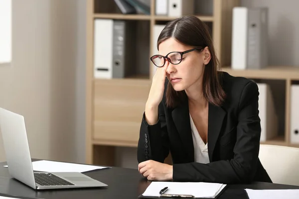 Stressed young woman at workplace in office — Stock Photo, Image