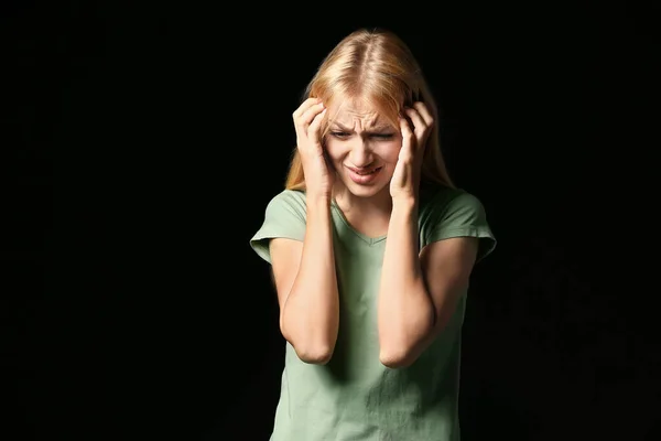 Stressed young woman on dark background — Stock Photo, Image