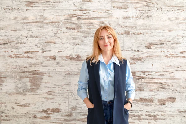 Portrait of stylish mature businesswoman on wooden background — Stock Photo, Image