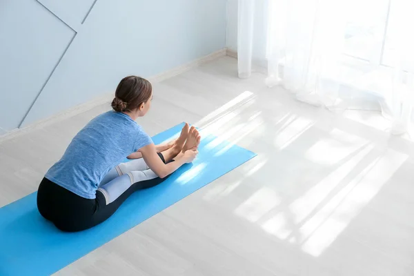 Giovane donna che pratica yoga a casa — Foto Stock