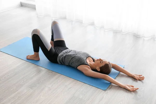 Mujer joven practicando yoga en casa — Foto de Stock