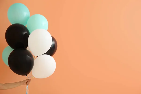 Female hand with air balloons on color background — Stock Photo, Image