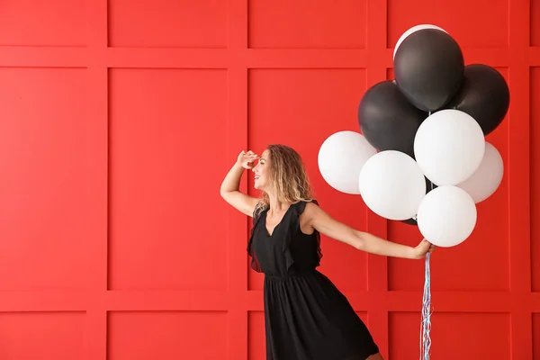 Bella giovane donna con palloncini su sfondo di colore — Foto Stock