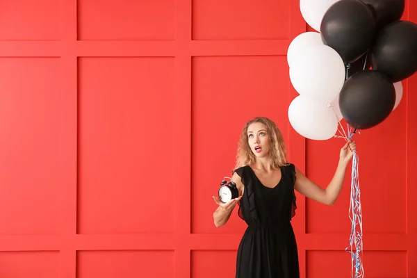 Hermosa mujer joven con globos y reloj sobre fondo de color —  Fotos de Stock