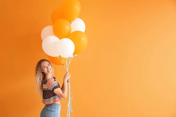 Bella giovane donna con palloncini su sfondo di colore — Foto Stock