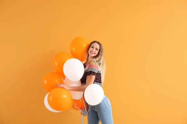 Bella giovane donna con palloncini su sfondo di colore — Foto Stock