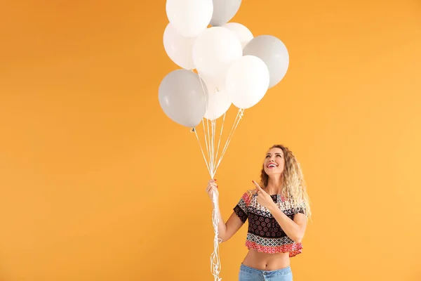 Красивая девушка с воздушными шарами на цветном фоне — стоковое фото