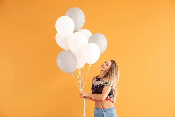 Beautiful young woman with balloons on color background — Stock Photo, Image
