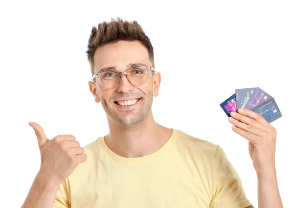 Young man with credit cards showing thumb-up gesture on white background — Stock Photo, Image